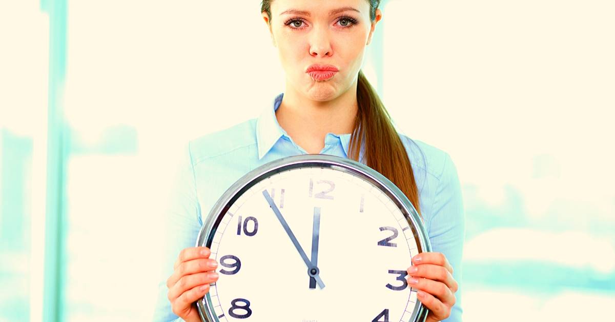 Frau mit Uhr - Kurzarbeit in der Zahnarztpraxis