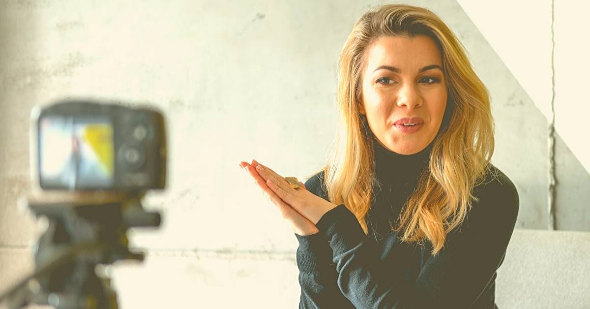 Junge Frau vor Videokamera. Die Videosprechstunde in der Zahnarztpraxis gewinnt an Akzeptanz.